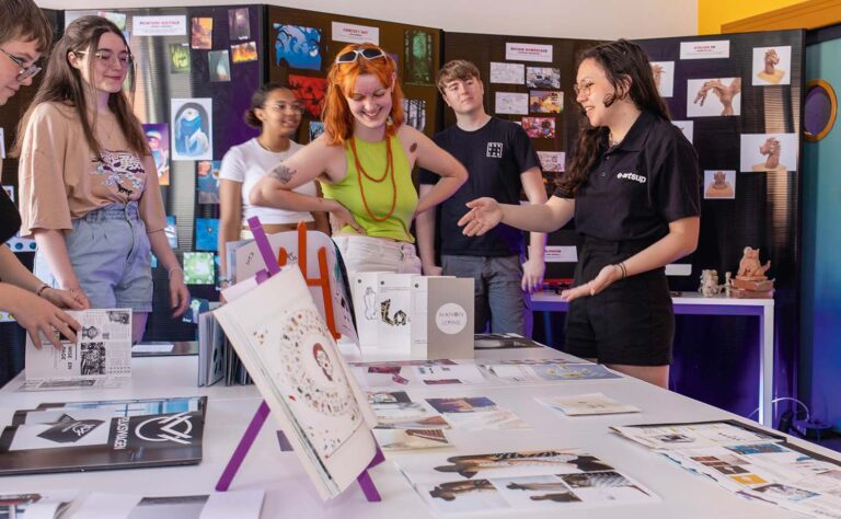 Étudiants d'e-artsup présentant leurs travaux créatifs lors d'une exposition