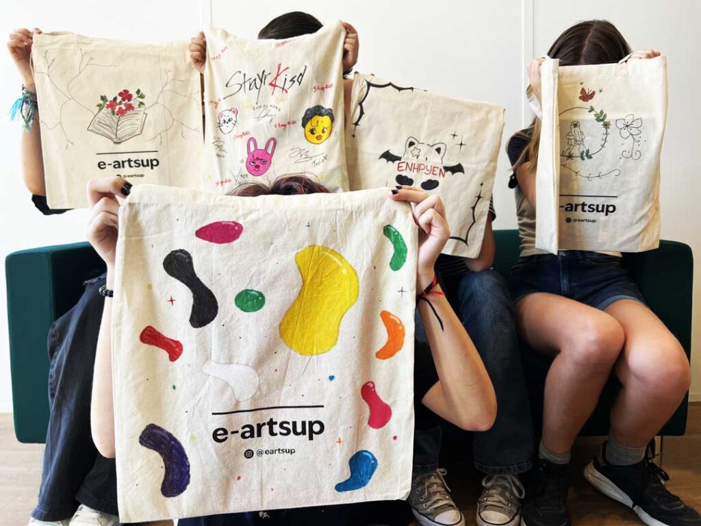 Des élèves de seconde présentent les tote bags personnalisés qu’ils ont réalisés pendant un atelier créatif à e-artsup Lyon.