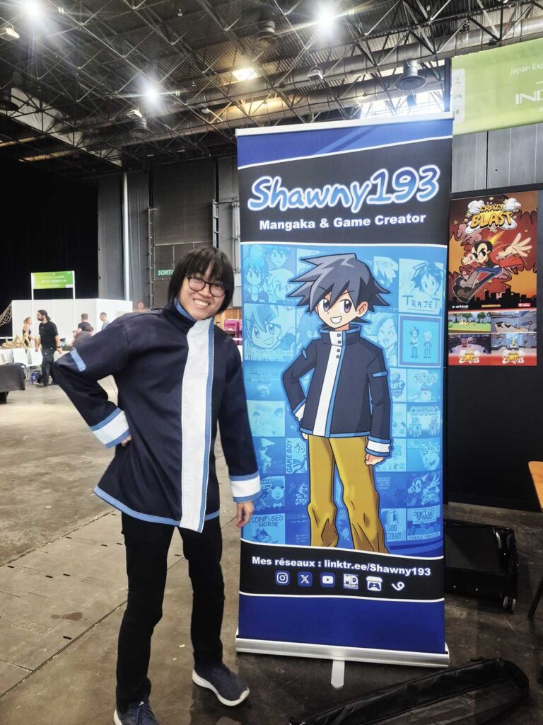 Créateur diplômé d’e-artsup devant son kakémono de mangaka et game creator sur son stand à Japan Expo 2026.