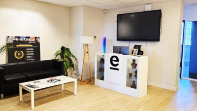 Espace d’accueil du campus e-artsup Strasbourg avec canapé, écran et comptoir