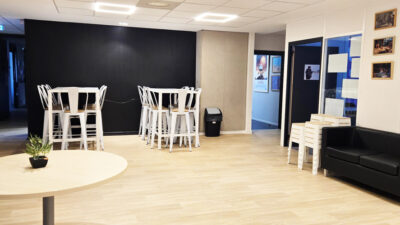 Espace de convivialité du campus e-artsup Strasbourg avec tables hautes et canapé
