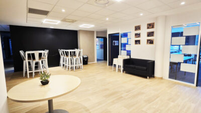 Lieu de vie du campus e-artsup Strasbourg avec canapé, tables hautes et salles vitrées